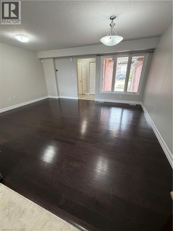 Unfurnished room featuring a textured ceiling and dark wood-type flooring - 45 Brookfield Crescent, Kitchener, ON - Indoor Photo Showing Other Room
