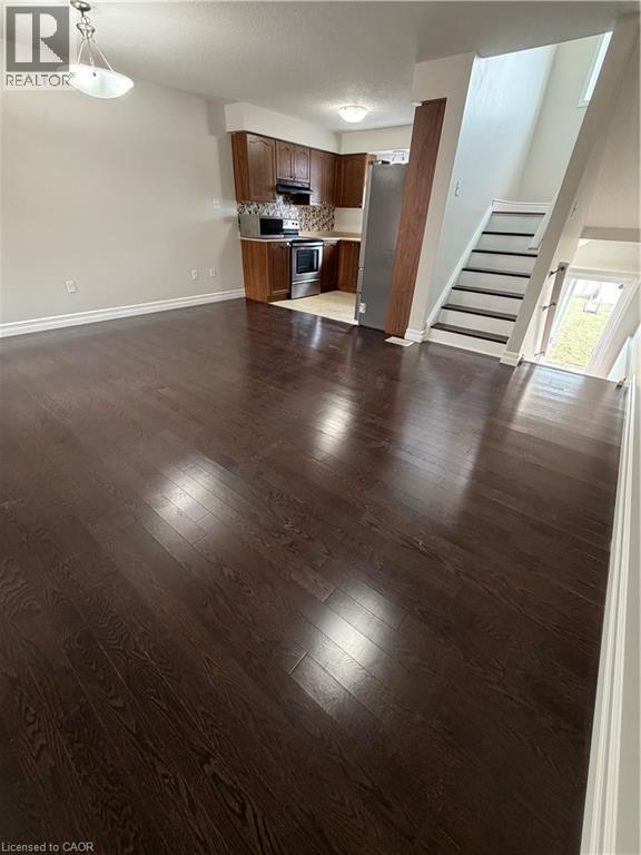 Unfurnished living room with stairway and dark wood-style floors - 45 Brookfield Crescent, Kitchener, ON - Indoor