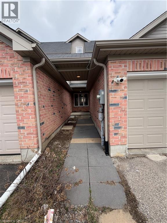View of exterior entry featuring brick siding, a shingled roof, and a garage - 45 Brookfield Crescent, Kitchener, ON - Outdoor With Exterior