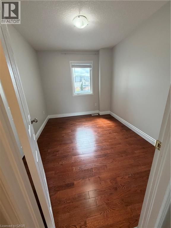 Unfurnished room with dark wood finished floors and a textured ceiling - 45 Brookfield Crescent, Kitchener, ON - Indoor Photo Showing Other Room