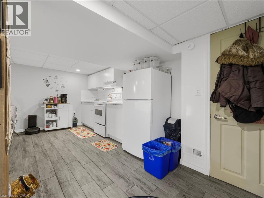 Kitchen featuring a drop ceiling, white appliances, light wood-type flooring, white cabinetry, and open shelves - 420 Waverly Street, Hamilton, ON - Indoor