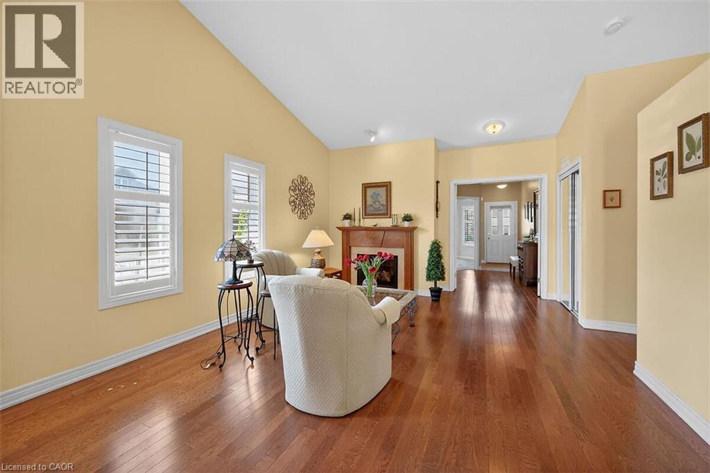 Living room with hardwood / wood-style floors, a fireplace, and lofted ceiling - 48 Hallmark Trail, Hamilton, ON - Indoor With Fireplace