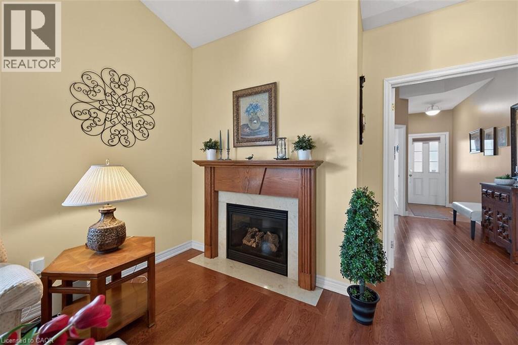 Living area featuring dark wood-style floors and a fireplace - 48 Hallmark Trail, Hamilton, ON - Indoor Photo Showing Living Room With Fireplace