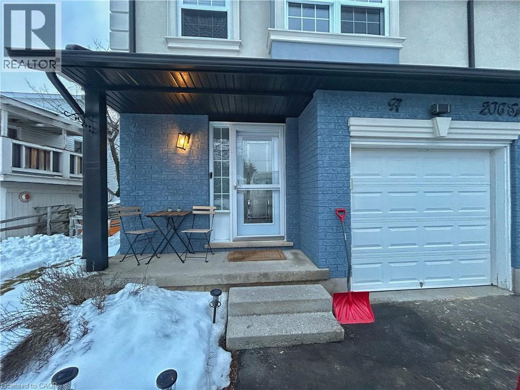 Property entrance with a porch, stucco siding, and a garage - 206A Springfield Crescent Unit# Lower, Waterloo, ON - Outdoor