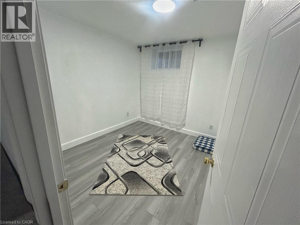 Unfurnished room featuring light wood-style flooring and baseboards - 206A Springfield Crescent Unit# Lower, Waterloo, ON - Indoor