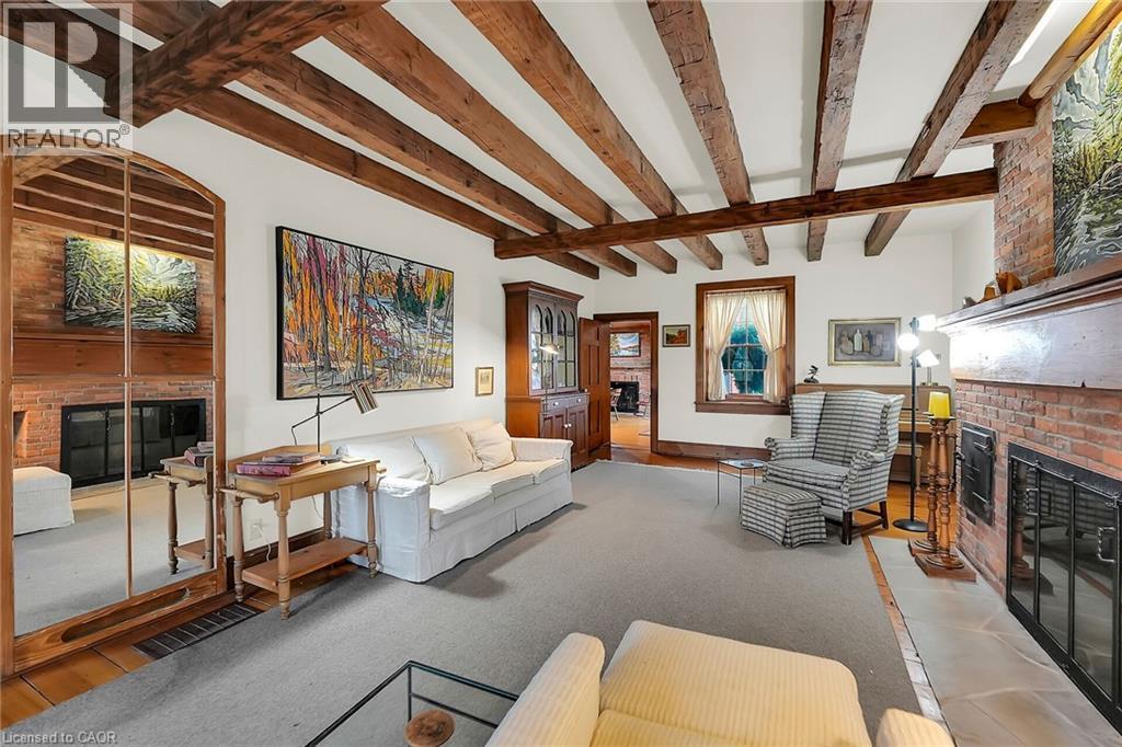 Living area with a fireplace, beamed ceiling, and light colored carpet - 2432 Seburn Road, Fonthill, ON - Indoor With Fireplace