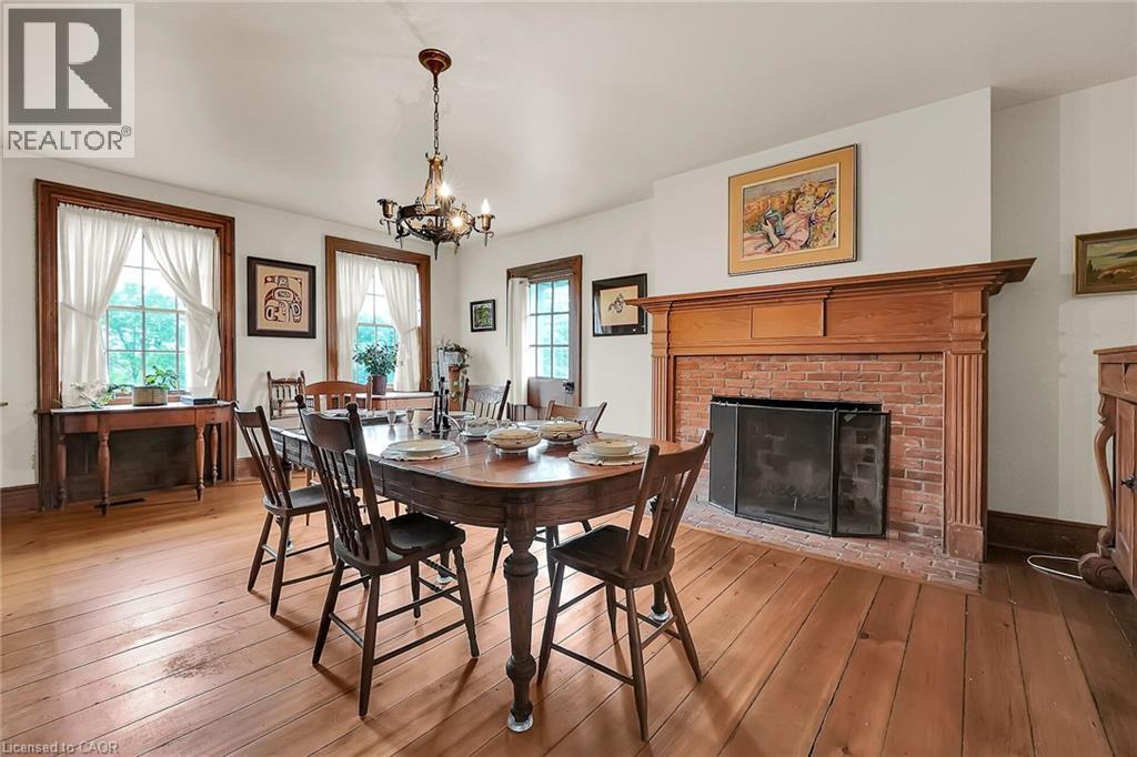 Dining room featuring wood-type flooring, a fireplace, and suspended lighting - 2432 Seburn Road, Fonthill, ON - Indoor Photo Showing Dining Room With Fireplace