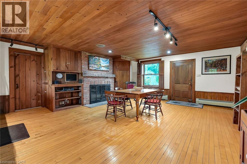 Dining room featuring track lighting, wooden walls, wainscoting, wooden ceiling, and a fireplace - 2432 Seburn Road, Fonthill, ON - Indoor With Fireplace