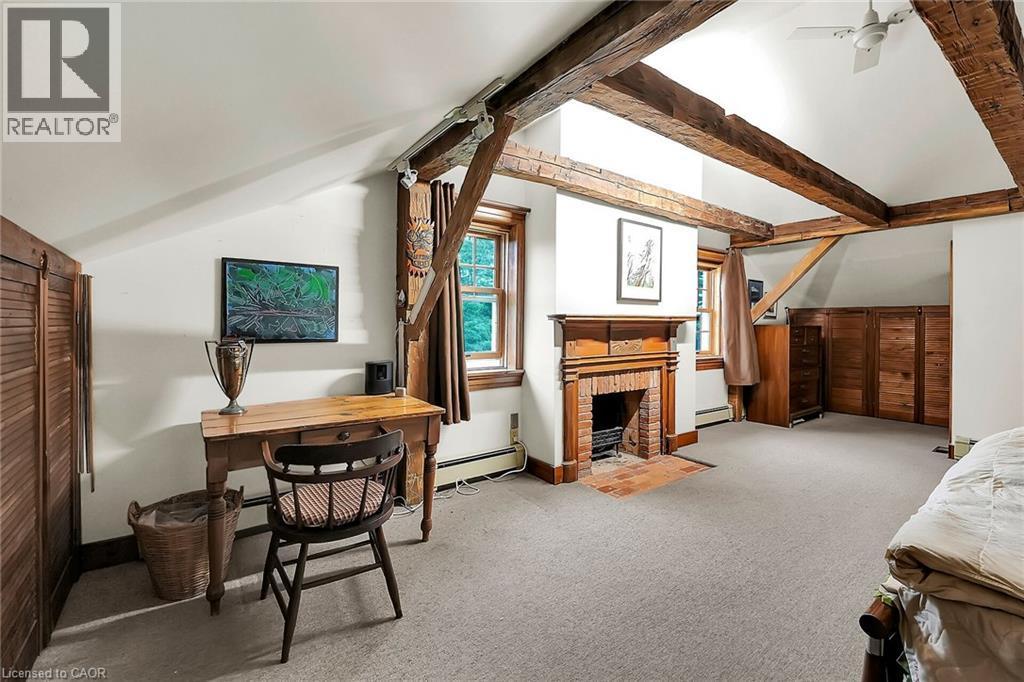 Bedroom featuring vaulted ceiling, light colored carpet, a fireplace, baseboard heating, and a baseboard radiator - 2432 Seburn Road, Fonthill, ON - Indoor With Fireplace