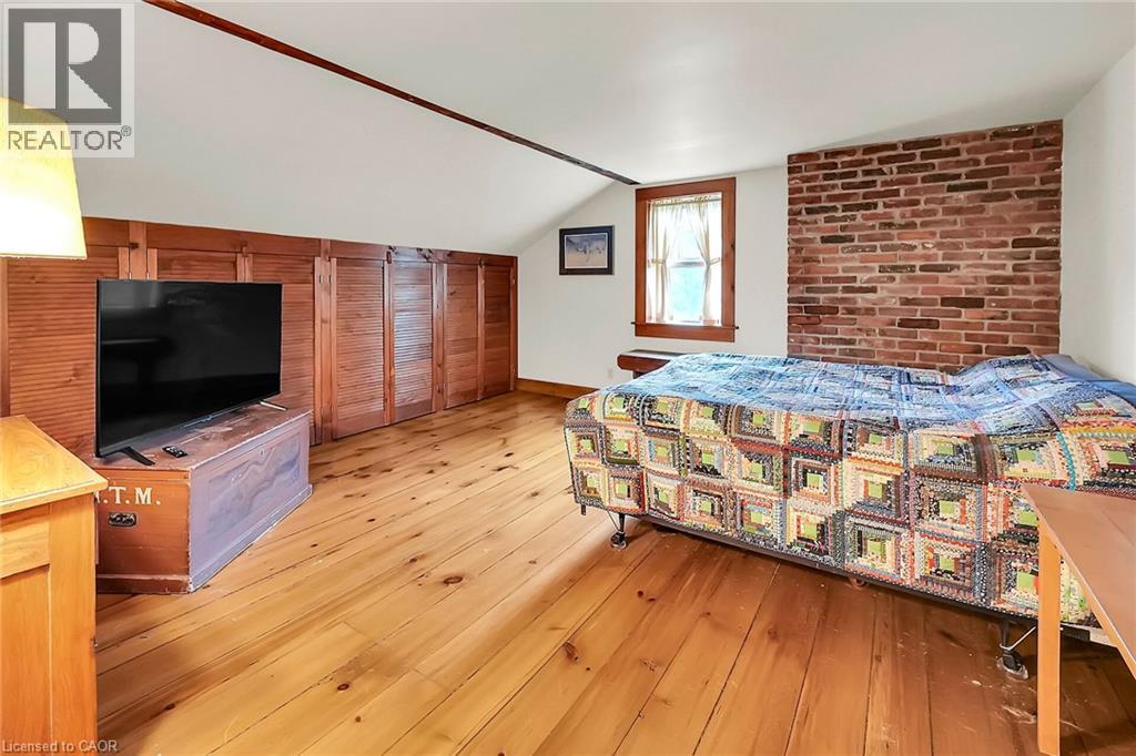Bedroom with light wood finished floors, lofted ceiling, and brick wall - 2432 Seburn Road, Fonthill, ON - Indoor