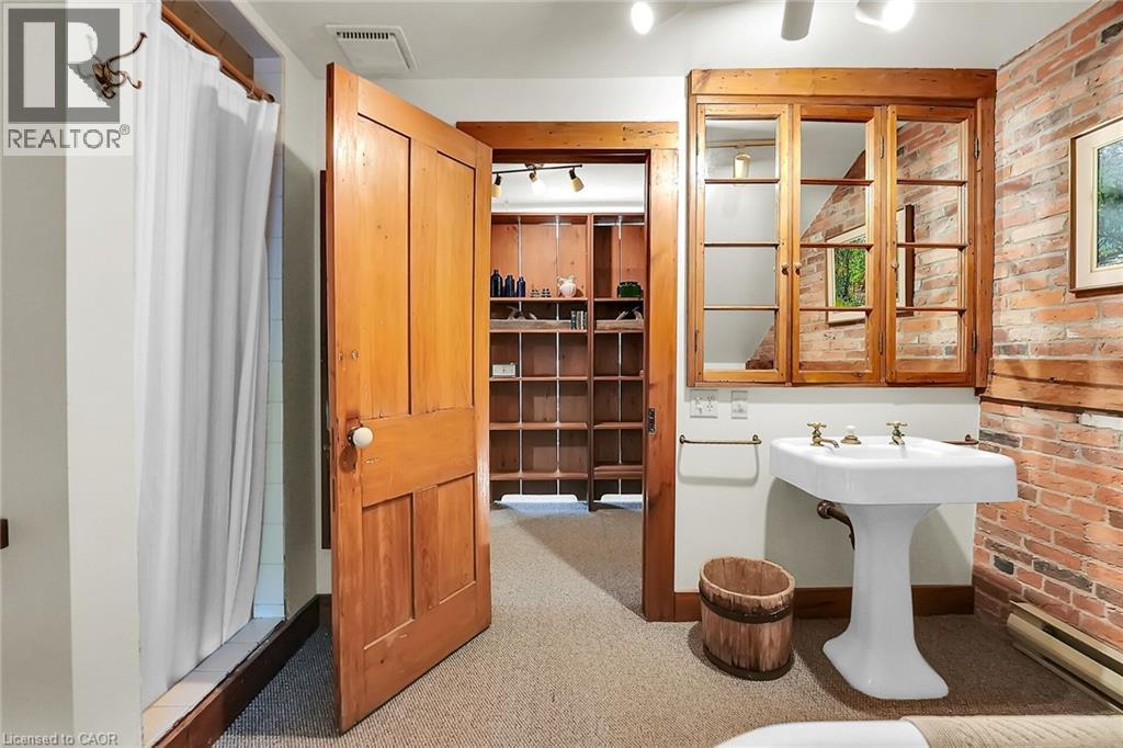 Full bath with a shower stall, brick wall, a baseboard heating unit, and light carpet - 2432 Seburn Road, Fonthill, ON - Indoor Photo Showing Bathroom