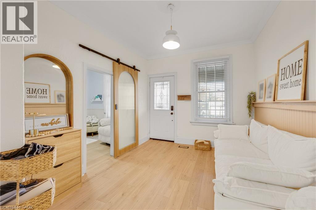 Entryway with light wood-style floors, a barn door, and ornamental molding - 6 Ben Lomond Place, Hamilton, ON - Indoor Photo Showing Other Room