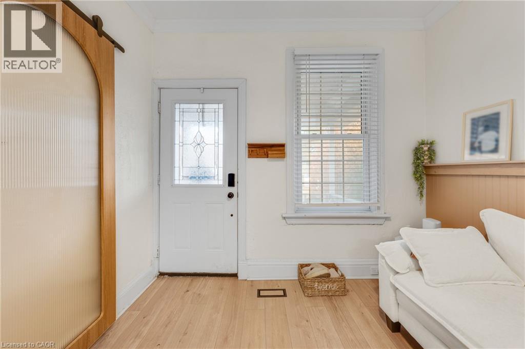 Foyer entrance featuring ornamental molding, light wood-type flooring, and a barn door - 6 Ben Lomond Place, Hamilton, ON - Indoor Photo Showing Other Room