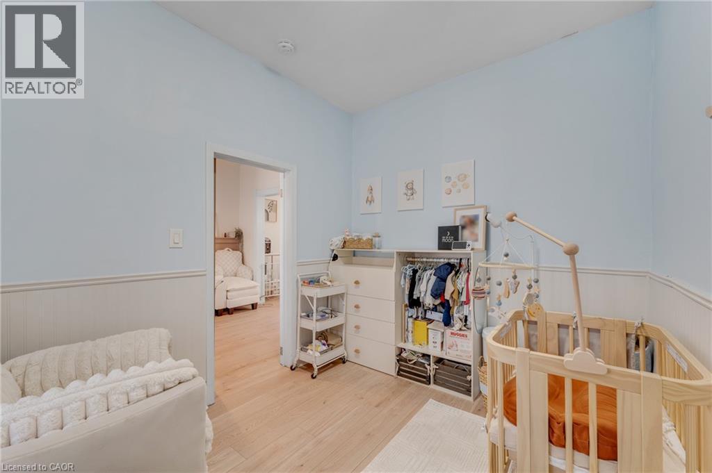 Bedroom featuring a nursery area, a wainscoted wall, and light wood-style floors - 6 Ben Lomond Place, Hamilton, ON - Indoor Photo Showing Bedroom