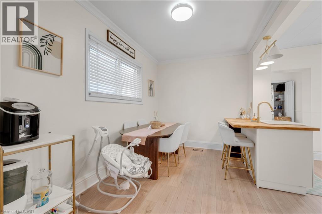 Dining area with light wood finished floors and crown molding - 6 Ben Lomond Place, Hamilton, ON - Indoor Photo Showing Dining Room