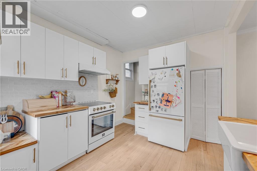 Kitchen with wood counters, white cabinetry, white appliances, light wood-style flooring, and backsplash - 6 Ben Lomond Place, Hamilton, ON - Indoor Photo Showing Kitchen