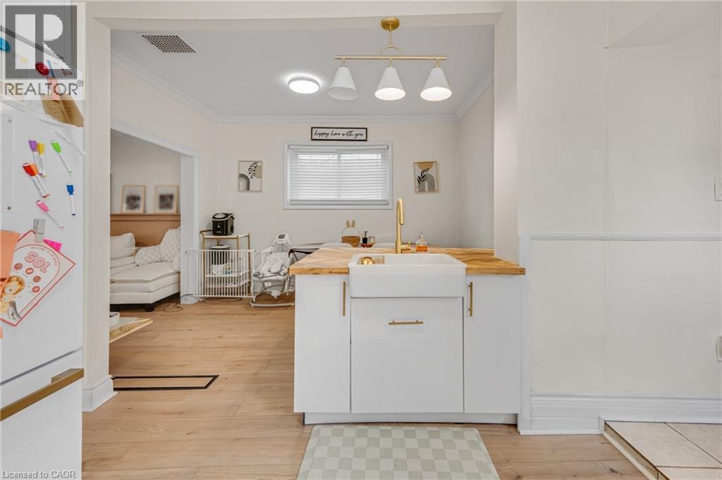 Kitchen featuring freestanding refrigerator, ornamental molding, butcher block countertops, white cabinets, and light wood finished floors - 6 Ben Lomond Place, Hamilton, ON - Indoor Photo Showing Other Room