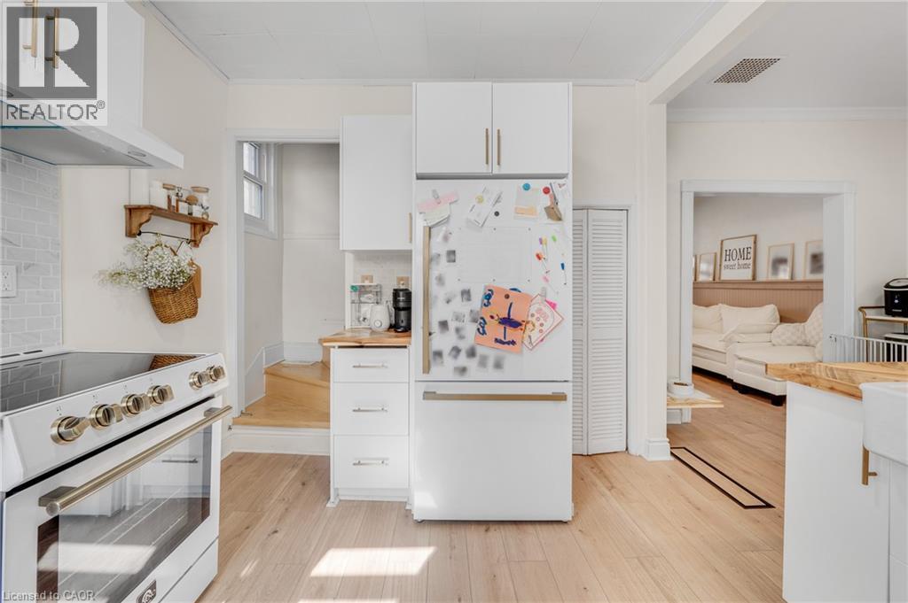 Kitchen featuring white cabinetry, white appliances, ornamental molding, light wood-style flooring, and wood counters - 6 Ben Lomond Place, Hamilton, ON - Indoor Photo Showing Kitchen