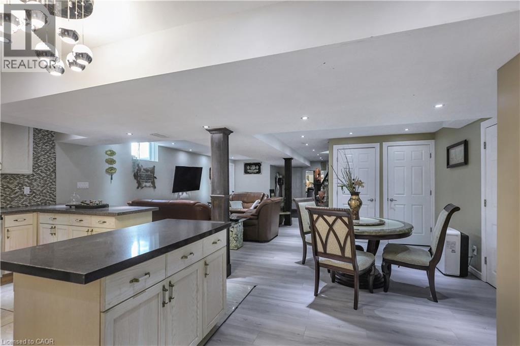 Kitchen featuring a kitchen island, open floor plan, dark countertops, tasteful backsplash, and light wood-type flooring - 254 Rymal Road W, Hamilton, ON - Indoor