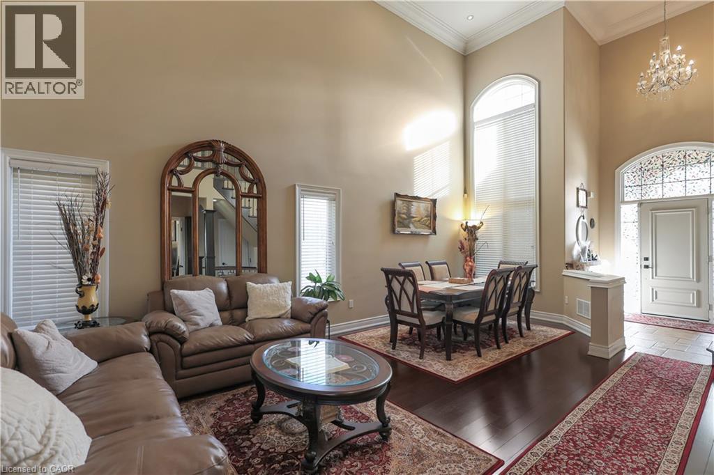 Living area with a high ceiling, ornamental molding, hardwood / wood-style floors, and suspended lighting - 254 Rymal Road W, Hamilton, ON - Indoor Photo Showing Living Room