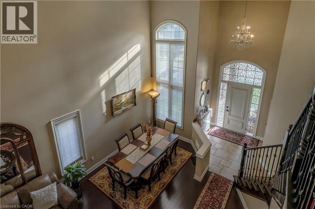 Entrance foyer featuring hanging lights, stone tile floors, and a high ceiling - 254 Rymal Road W, Hamilton, ON - Indoor Photo Showing Other Room With Fireplace
