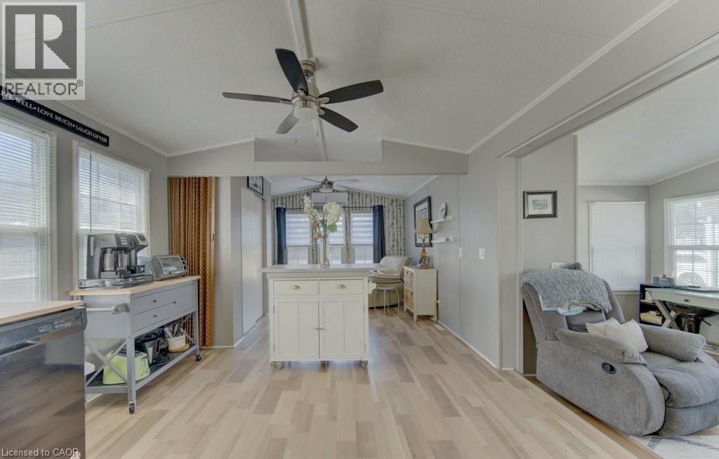 Kitchen with black dishwasher, open floor plan, light countertops, white cabinets, and light wood-style floors - 580 Beaver Creek Road Unit# 185, Waterloo, ON - Indoor