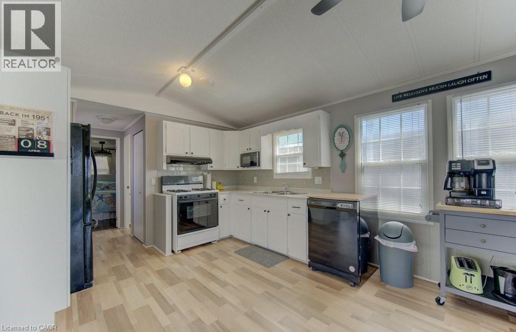 Kitchen featuring black appliances, a ceiling fan, light countertops, light wood-style floors, and white cabinetry - 580 Beaver Creek Road Unit# 185, Waterloo, ON - Indoor Photo Showing Kitchen