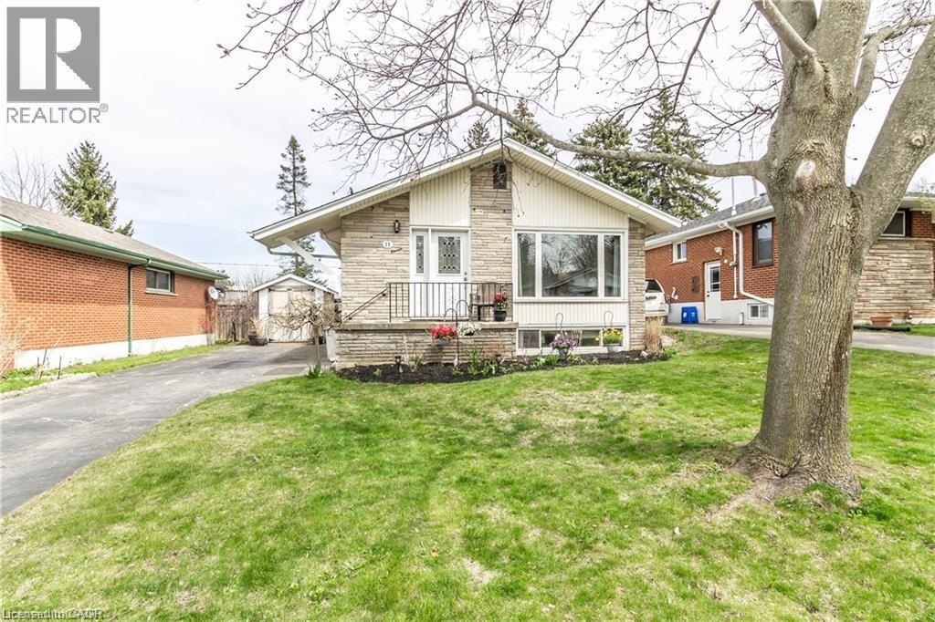 View of front of house with stone siding, a front lawn, and an outdoor structure - 11 Carwyn Crescent, Hamilton, ON - Outdoor With Deck Patio Veranda