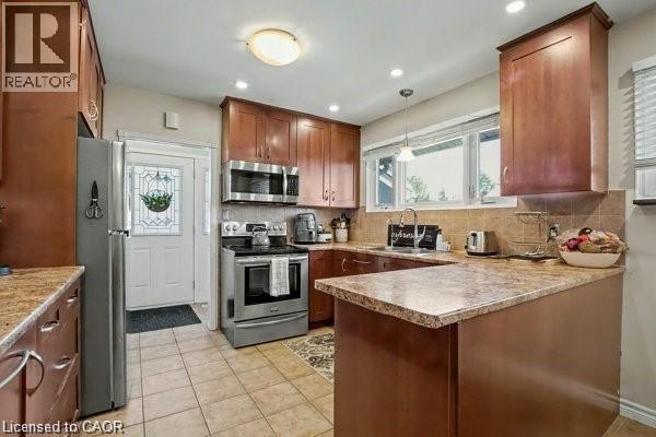 Kitchen featuring a peninsula, stainless steel appliances, plenty of natural light, and tasteful backsplash - 11 Carwyn Crescent, Hamilton, ON - Indoor Photo Showing Kitchen