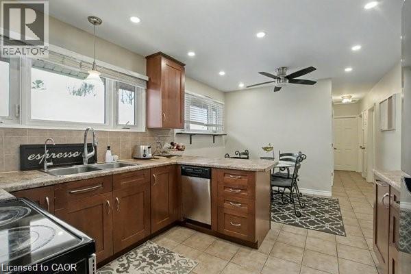 Kitchen featuring a peninsula, black range with electric stovetop, decorative backsplash, stainless steel dishwasher, and light tile patterned floors - 11 Carwyn Crescent, Hamilton, ON - Indoor Photo Showing Kitchen With Double Sink