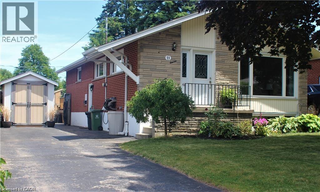 View of front of home with stone siding, a storage shed, and a front yard - 11 Carwyn Crescent, Hamilton, ON - Outdoor
