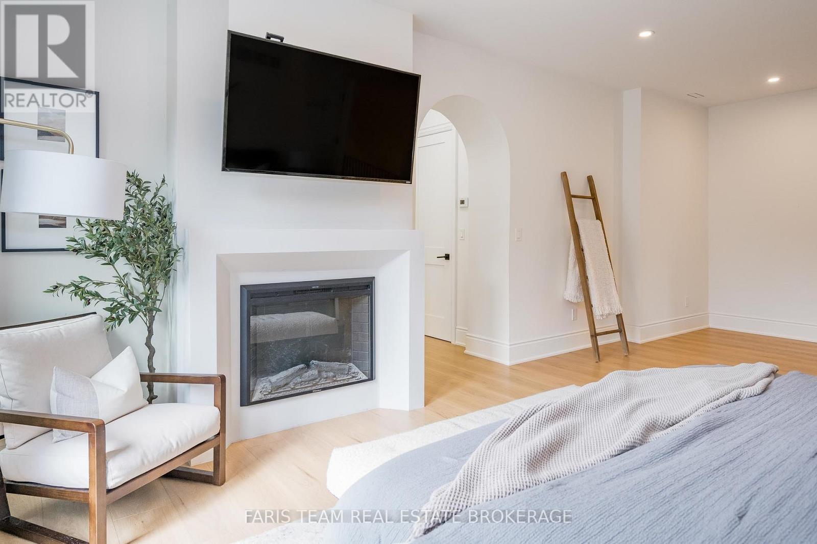 4 Sycamore Circle, Springwater, ON - Indoor Photo Showing Bedroom With Fireplace