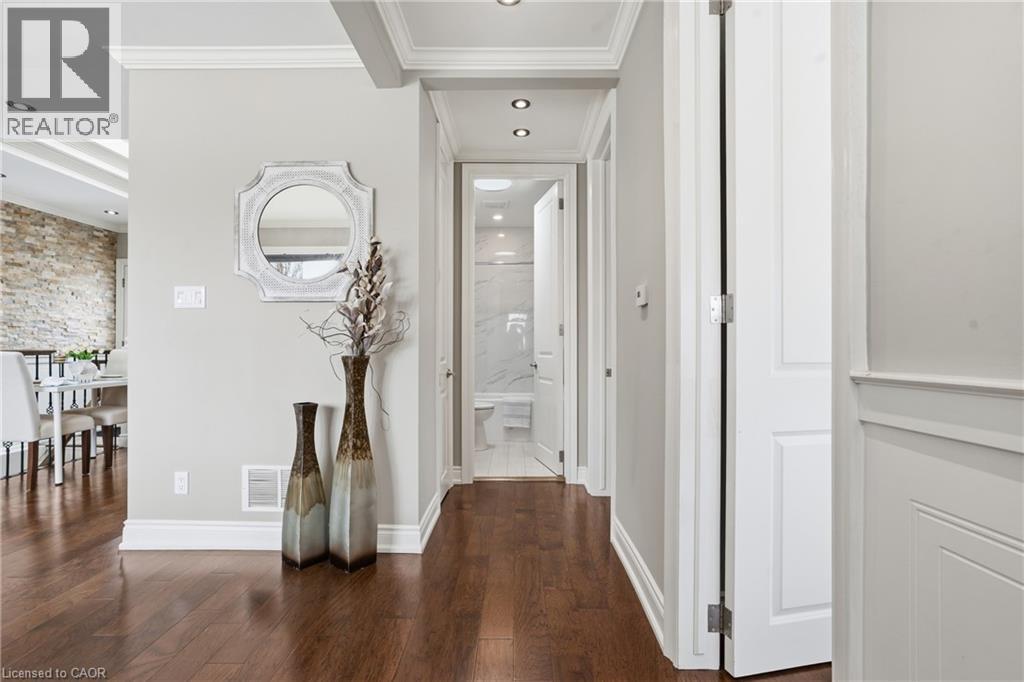 CUSTOM kitchen features stainless steel appliances, crown molding, white cabinetry, recessed lighting, hardwood floors & convenient access to rear yard. - 208 East 44Th Street, Hamilton, ON - Indoor Photo Showing Other Room