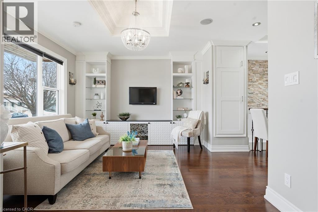 Quaint dining area with decorative stone accent wall and hardwood flooring. Patio door is ideal to access rear yard patio for BBQ'g. - 208 East 44Th Street, Hamilton, ON - Indoor Photo Showing Living Room