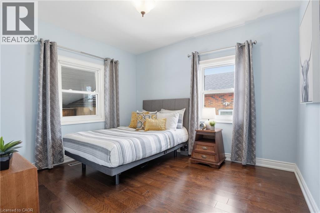 Full bathroom on main floor is GORGEOUS with neutral decor! Features generous vanity with elegant wall mounted fixtures, shower and tub combo. - 208 East 44Th Street, Hamilton, ON - Indoor Photo Showing Bedroom