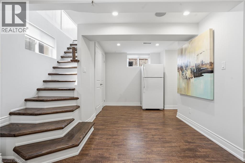 Family room offers a GORGEOUS accent wall, laminate wood flooring, recessed lighting & plenty of storage. Come fall in love! - 208 East 44Th Street, Hamilton, ON - Indoor Photo Showing Other Room