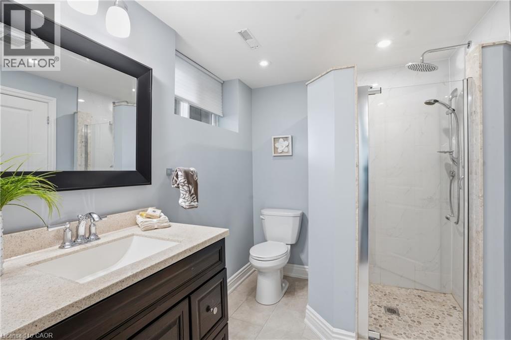 Lower level full bathroom with large vanity, a bright oversized shower, neutral tile floors, recessed lighting & large double closet for added storage. This house will wow you! - 208 East 44Th Street, Hamilton, ON - Indoor Photo Showing Bathroom