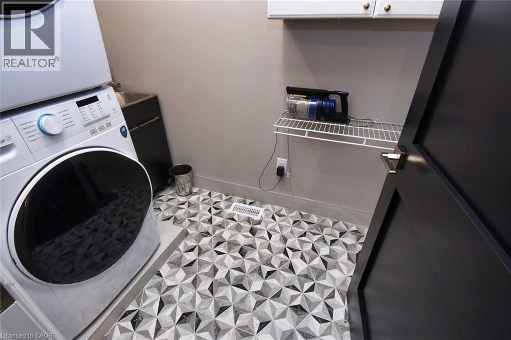 Laundry room with baseboards and stacked washing machine and dryer - 68 Mountain Brow Boulevard, Hamilton, ON - Indoor Photo Showing Laundry Room