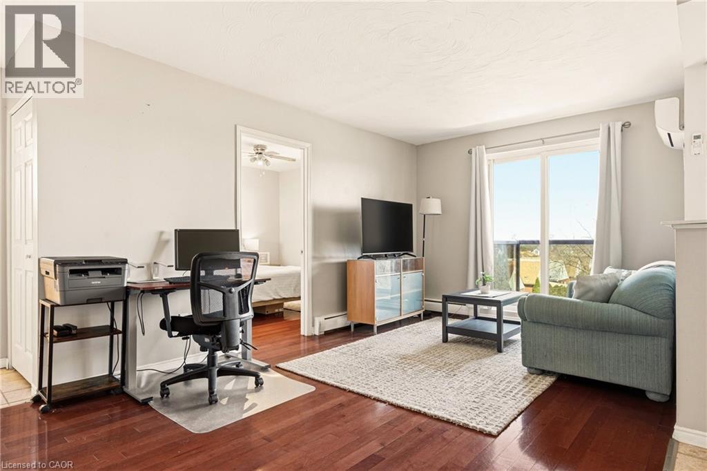 Living area with medium vinyl wood-style floors, an office area, sliding balcony doors to balcony - 2373 E King Street E Unit# 45, Hamilton, ON - Indoor
