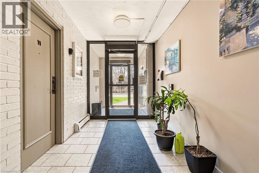 Entryway with brick wall and light tile patterned floors - 2373 E King Street E Unit# 45, Hamilton, ON - Indoor Photo Showing Other Room