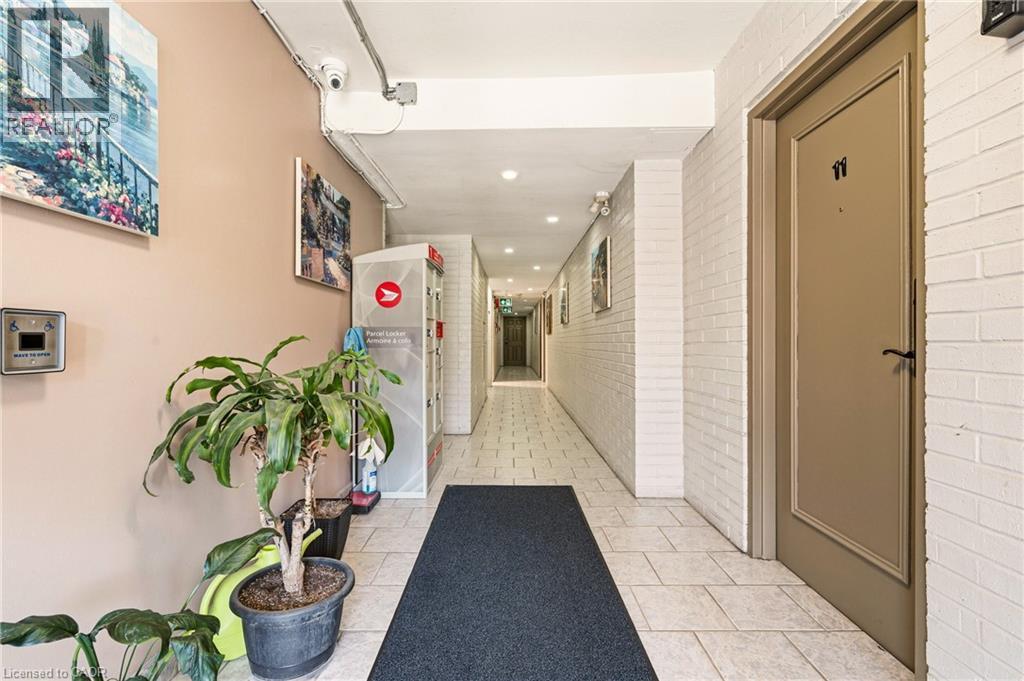 Corridor with brick wall, light tile patterned floors, and recessed lighting - 2373 E King Street E Unit# 45, Hamilton, ON - Indoor Photo Showing Other Room