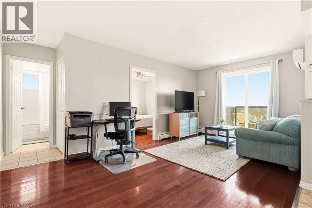 Living room featuring medium finish wood vinyl floors, sliding doors to balcony - 2373 E King Street E Unit# 45, Hamilton, ON - Indoor