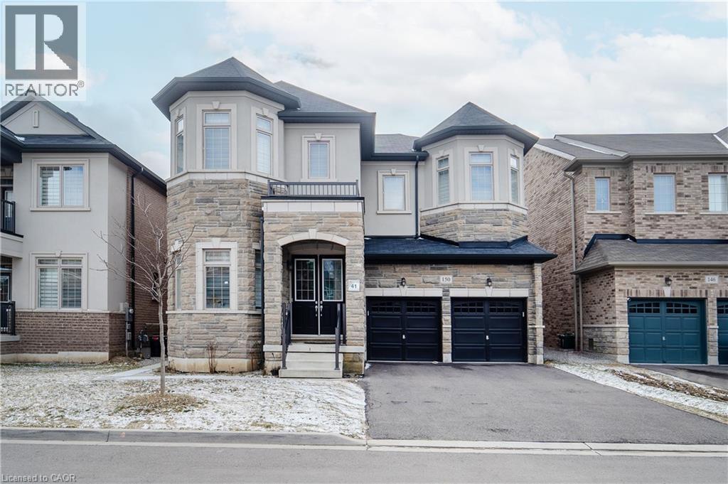View of front of property with stone siding, asphalt driveway, a balcony, and a garage - 150 Goodwin Crescent Unit# Bsmt, Milton, ON - Outdoor With Facade