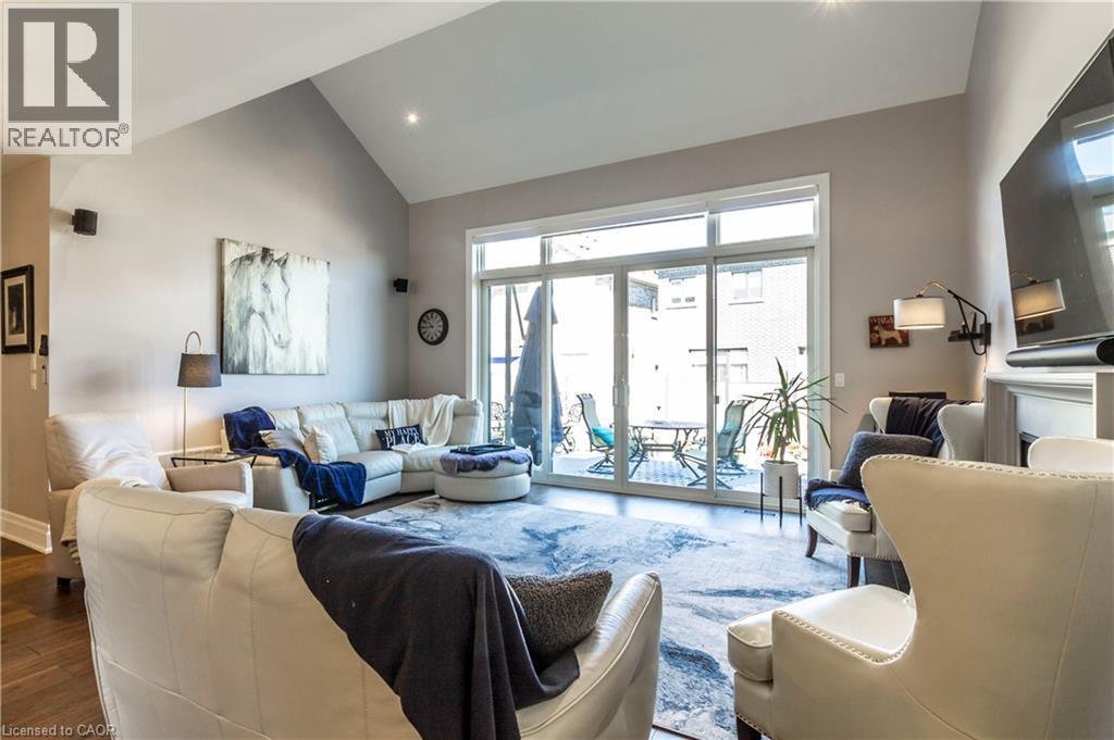 Living area featuring vaulted ceiling and wood finished floors - 72 Pond View Gate, Waterdown, ON - Indoor Photo Showing Living Room