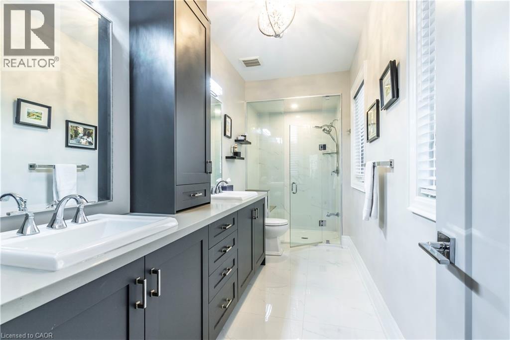 Full bath featuring double vanity, a marble finish shower, light marble finish flooring, and a chandelier - 72 Pond View Gate, Waterdown, ON - Indoor Photo Showing Bathroom