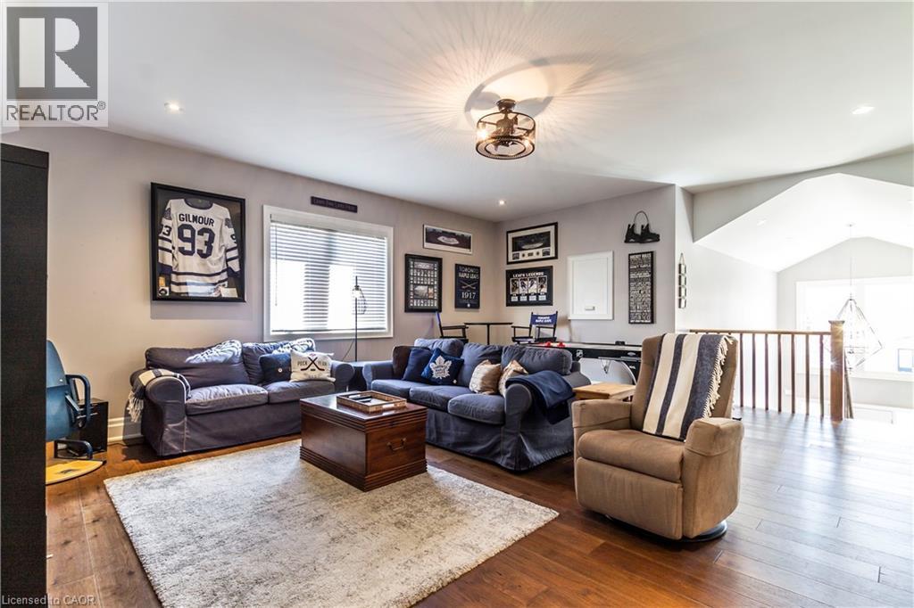 Living room with hardwood / wood-style flooring, lofted ceiling, and recessed lighting - 72 Pond View Gate, Waterdown, ON - Indoor Photo Showing Living Room