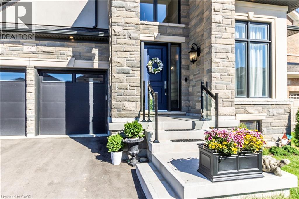 View of exterior entry with stone siding and driveway - 72 Pond View Gate, Waterdown, ON - Outdoor