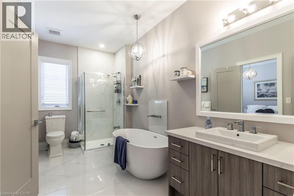Full bath with vanity, a marble finish shower, a freestanding tub, light marble finish floors, and connected bathroom - 72 Pond View Gate, Waterdown, ON - Indoor Photo Showing Bathroom