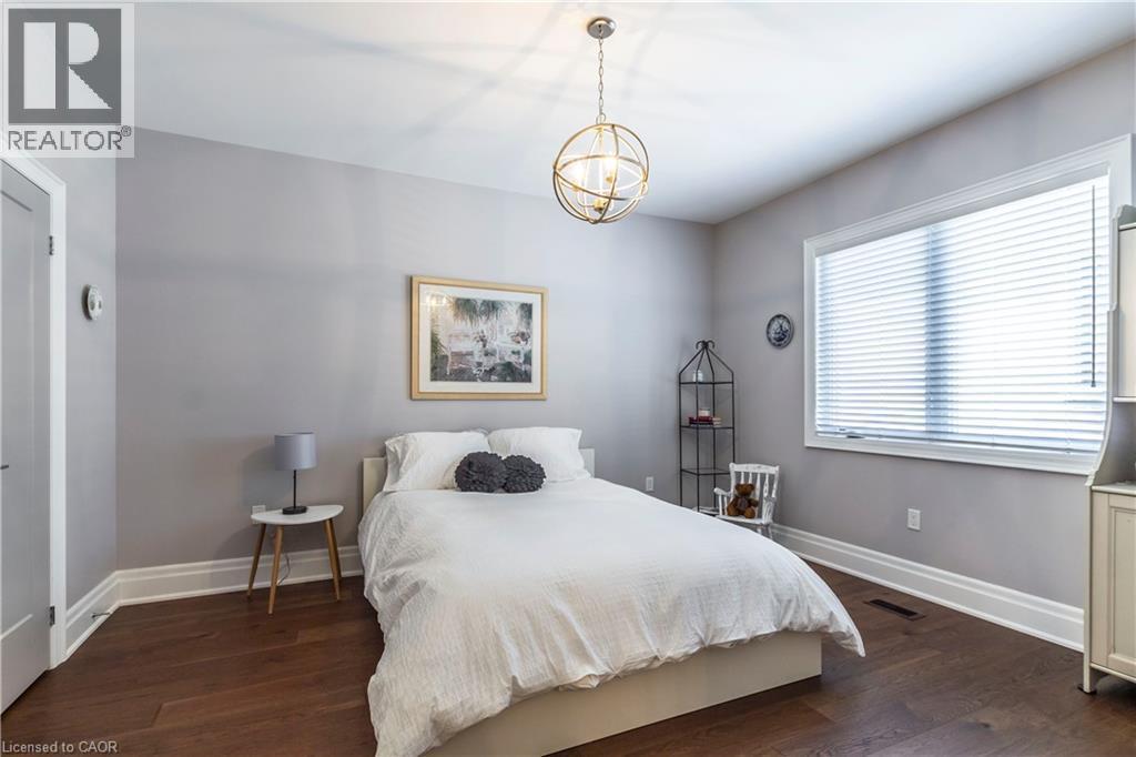 Bedroom with dark wood-style floors and hanging lights - 72 Pond View Gate, Waterdown, ON - Indoor Photo Showing Bedroom