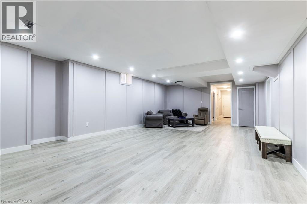 Living area with a decorative wall, light wood finished floors, and recessed lighting - 72 Pond View Gate, Waterdown, ON - Indoor Photo Showing Other Room